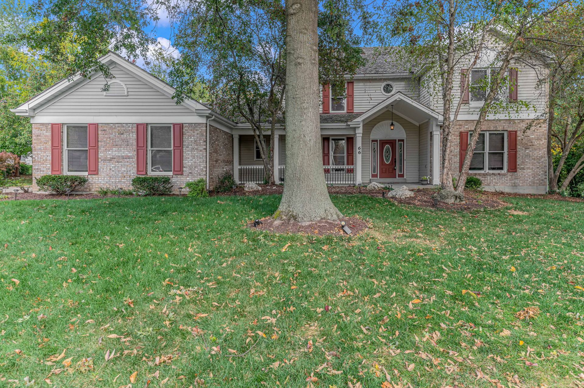 A large house with a large tree in front of it.
