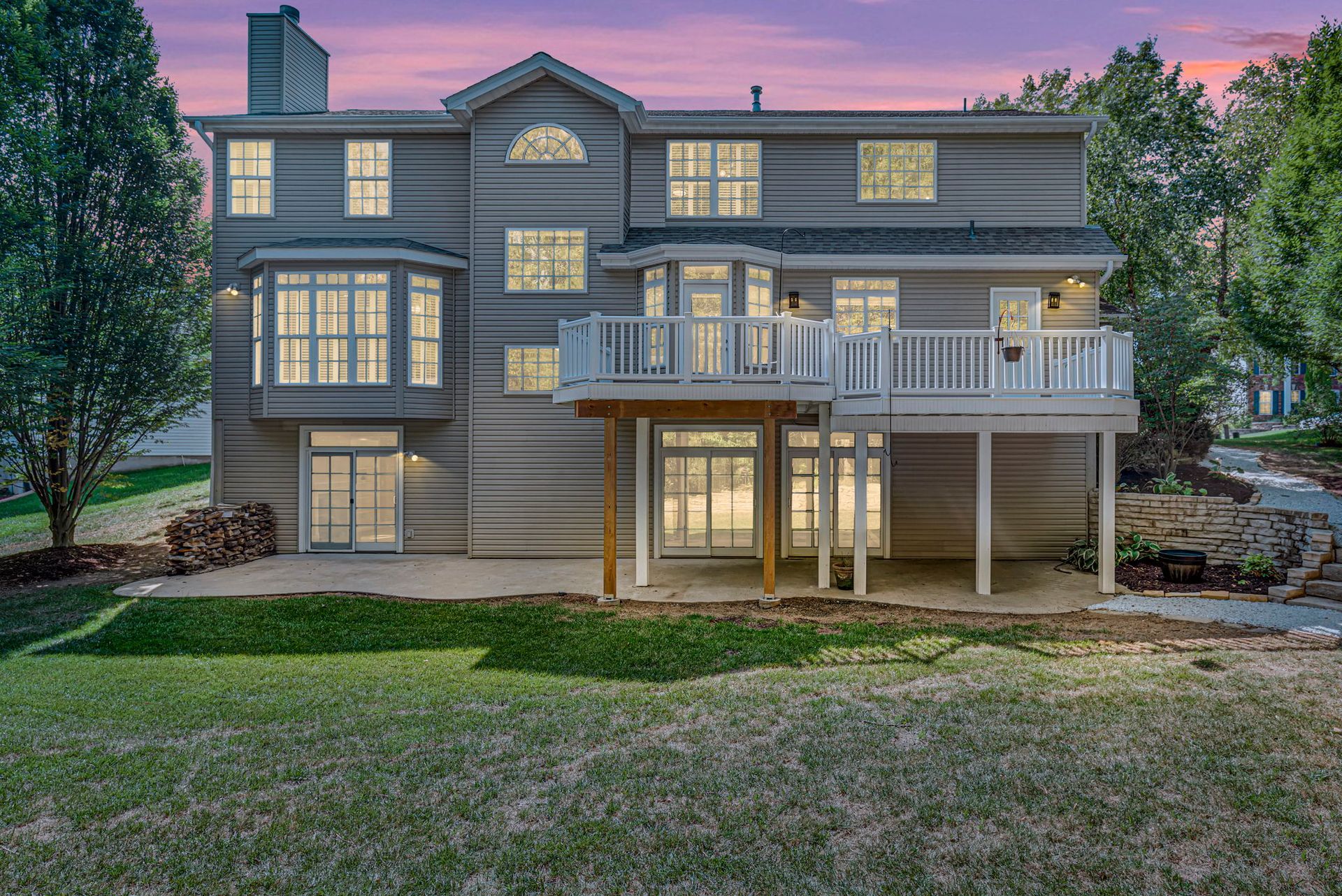 A large house with a large deck and a lot of windows