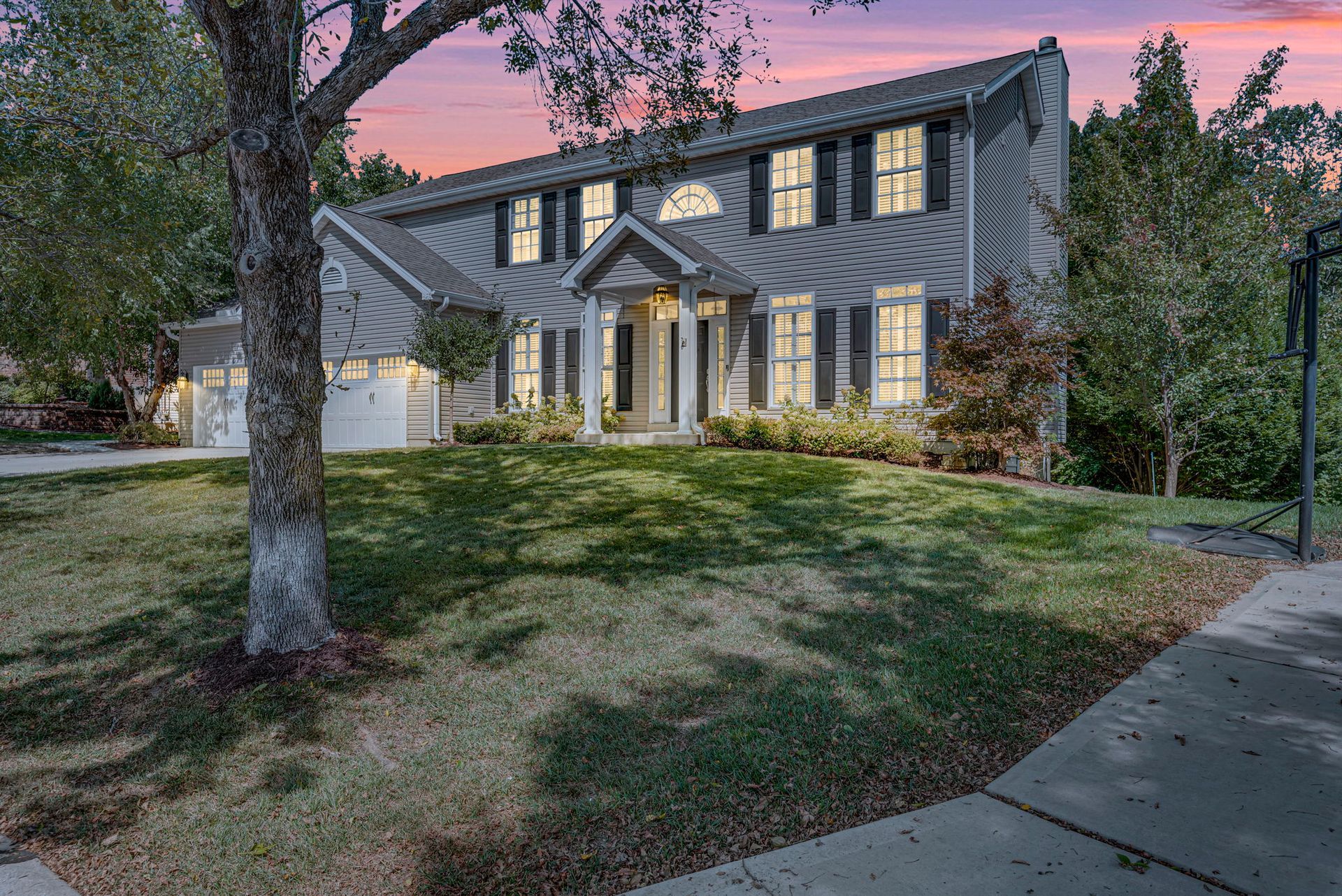 A large house with a lot of windows and a tree in front of it.