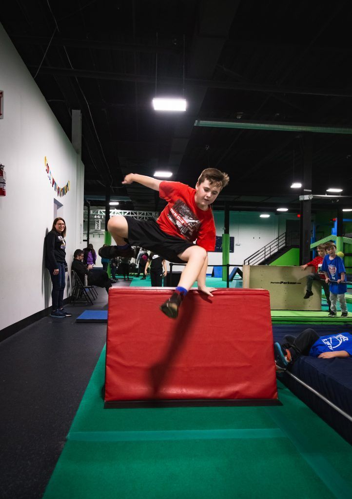 Boy jumping over obstacle