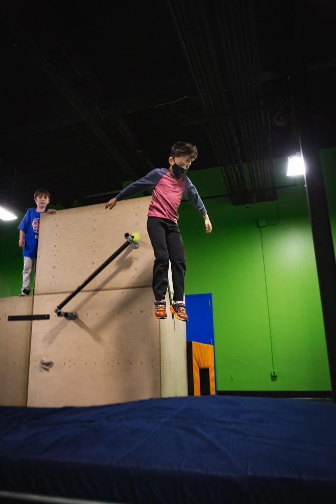 Young boy jumping on obstacle course