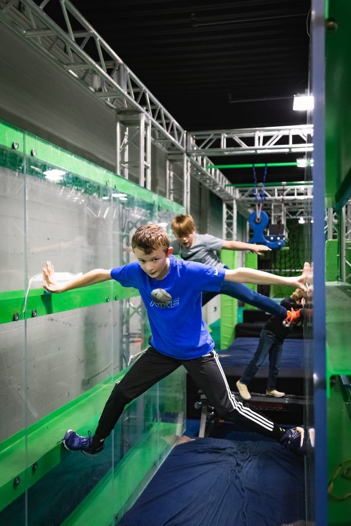 Boys climbing between two walls