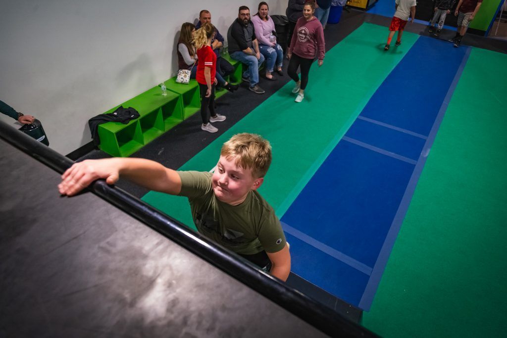 Young boy reaching top of a wall