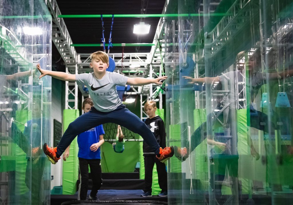 Boy climbing between two clear walls