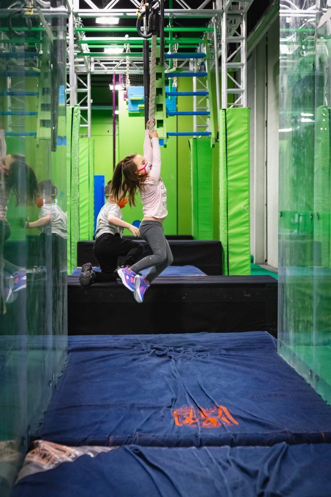 Young girl hanging from bars