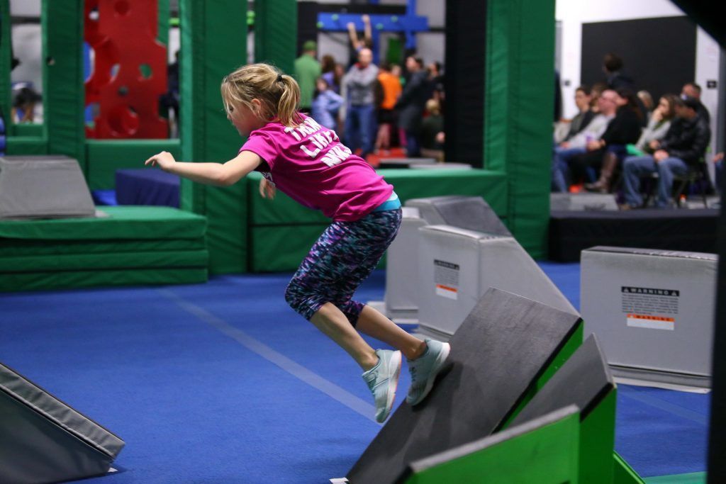 Young girl on ninja lab obstacle course