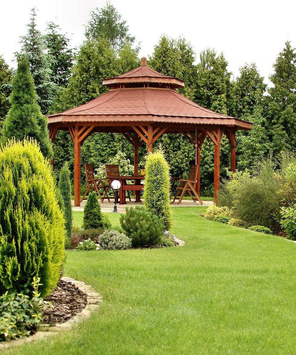 A gazebo in the middle of a lush green garden