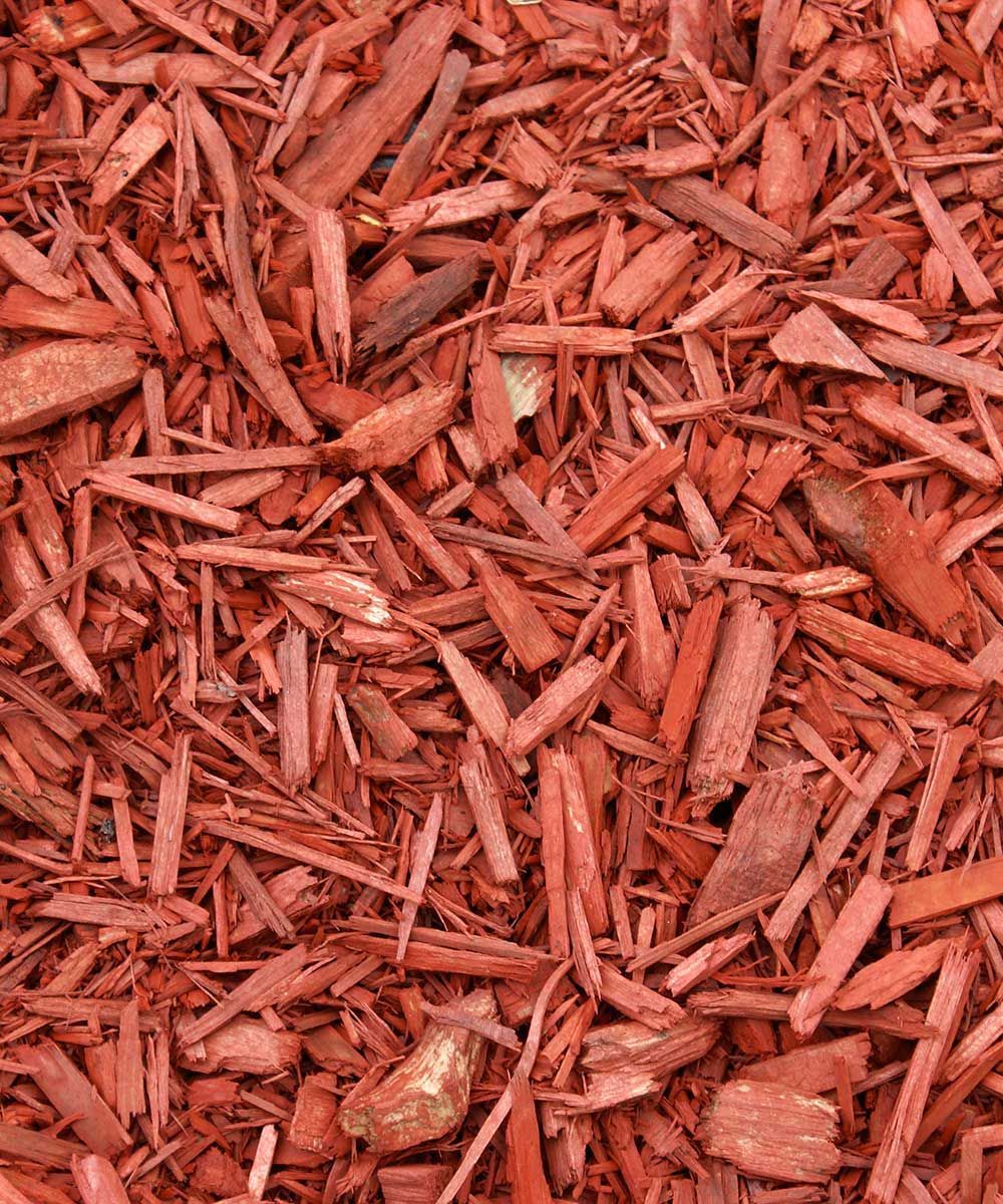 A pile of red mulch is sitting on the ground.