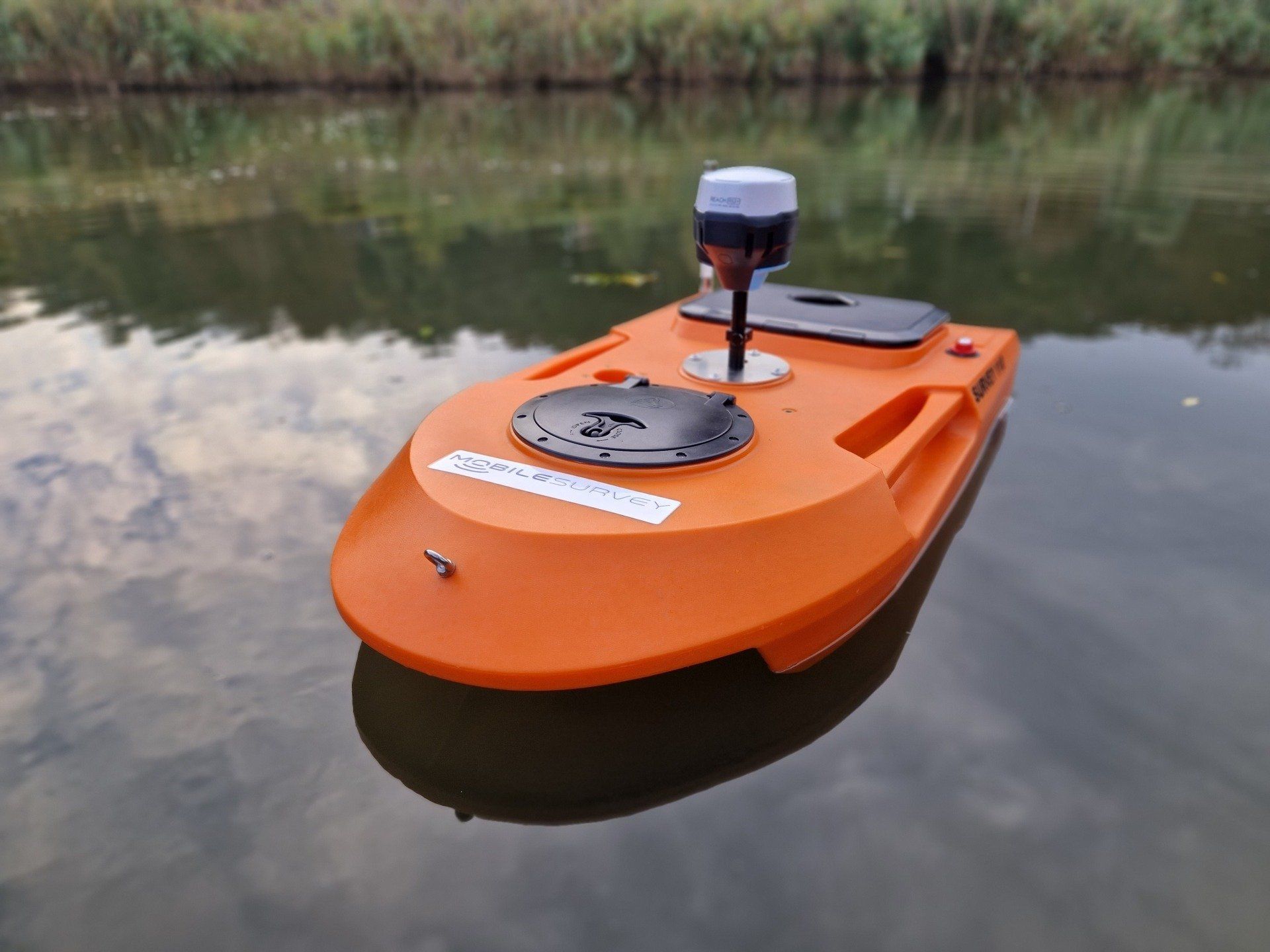 Een kleine oranje boot drijft op een watermassa.