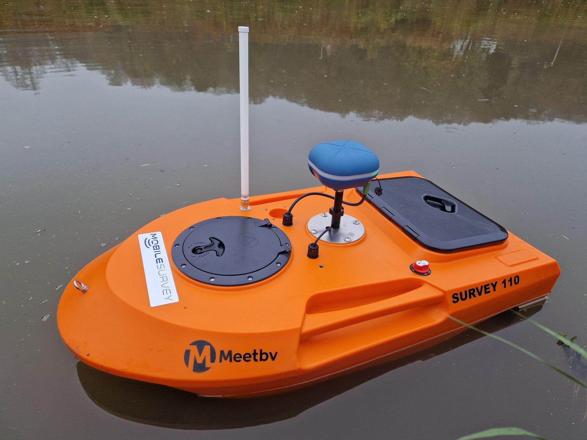Een kleine oranje boot drijft op een watermassa.