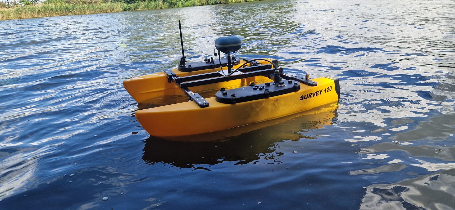 Een klein oranje bootje drijft op een meer.