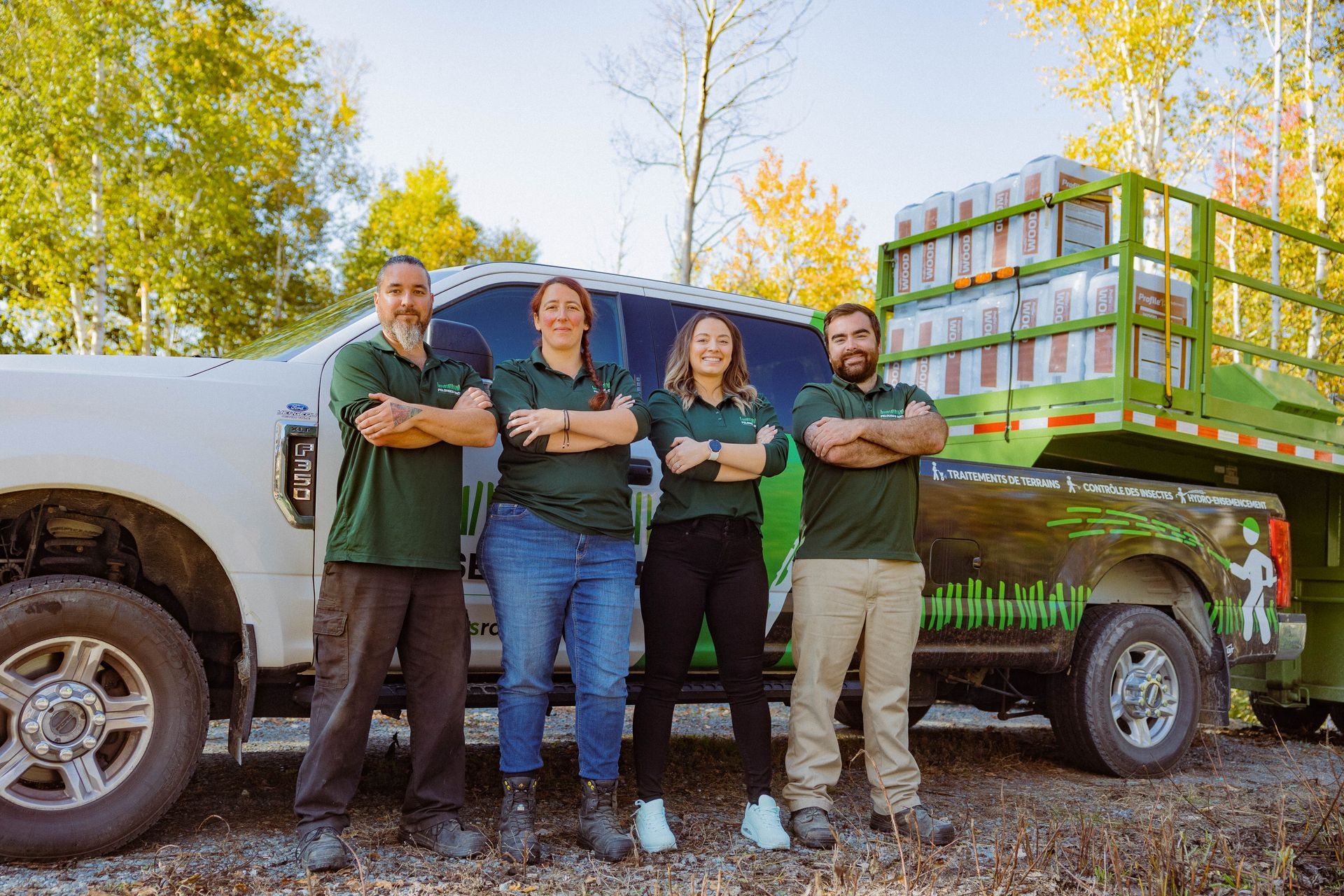 Un groupe de personnes pose pour une photo devant un camion.