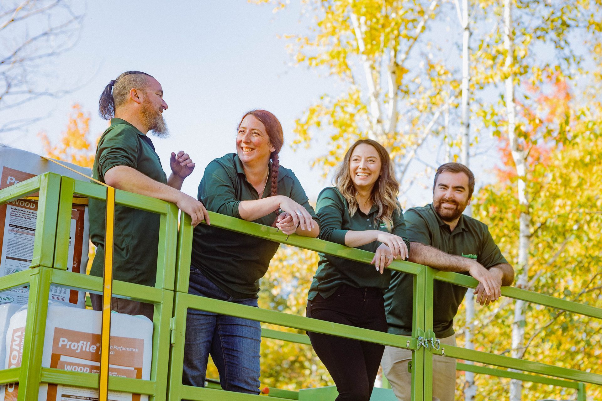 Un groupe de personnes s’appuie sur une balustrade verte.