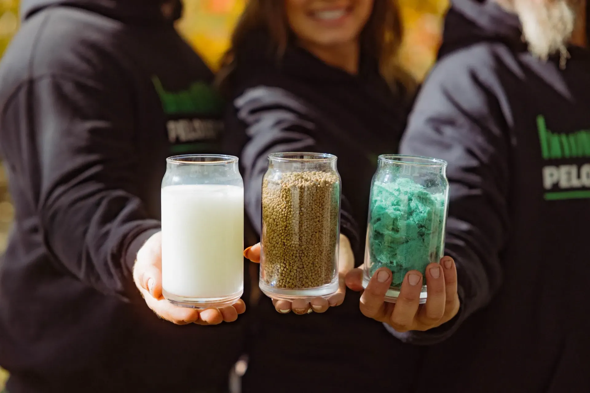 Un groupe de personnes tient des verres de lait et de céréales.