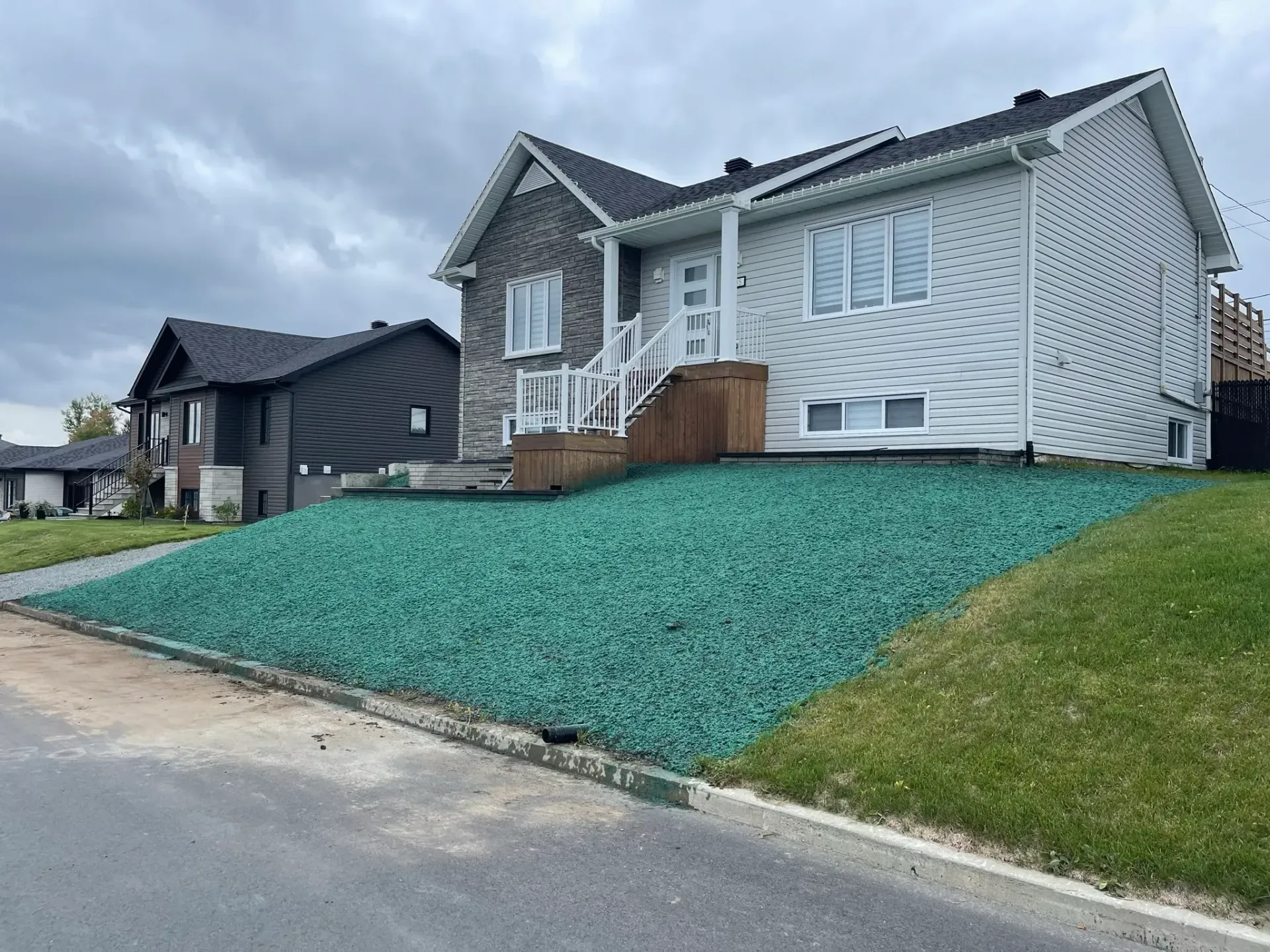 Une maison blanche avec une pelouse verte devant.