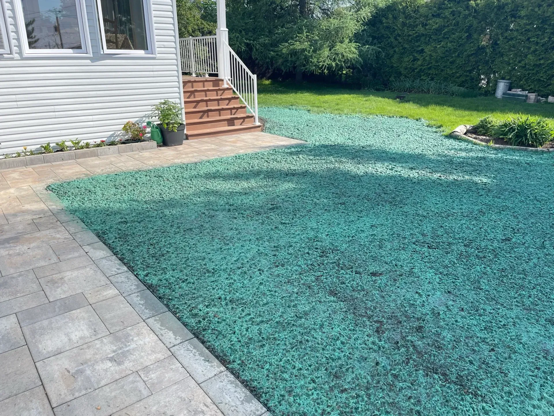 Une maison blanche avec une pelouse verte devant.