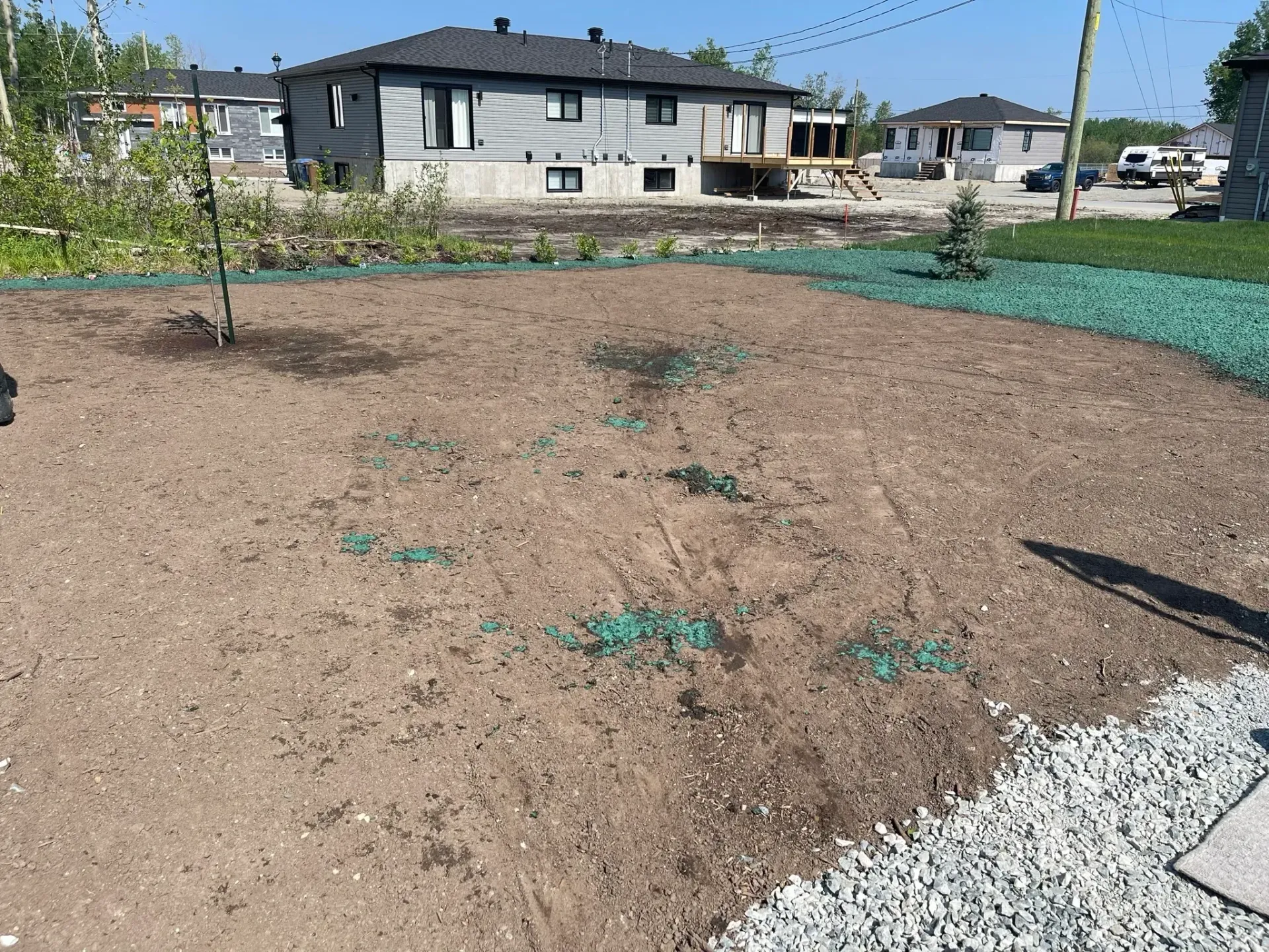 Un grand champ de terre avec une maison en arrière-plan.