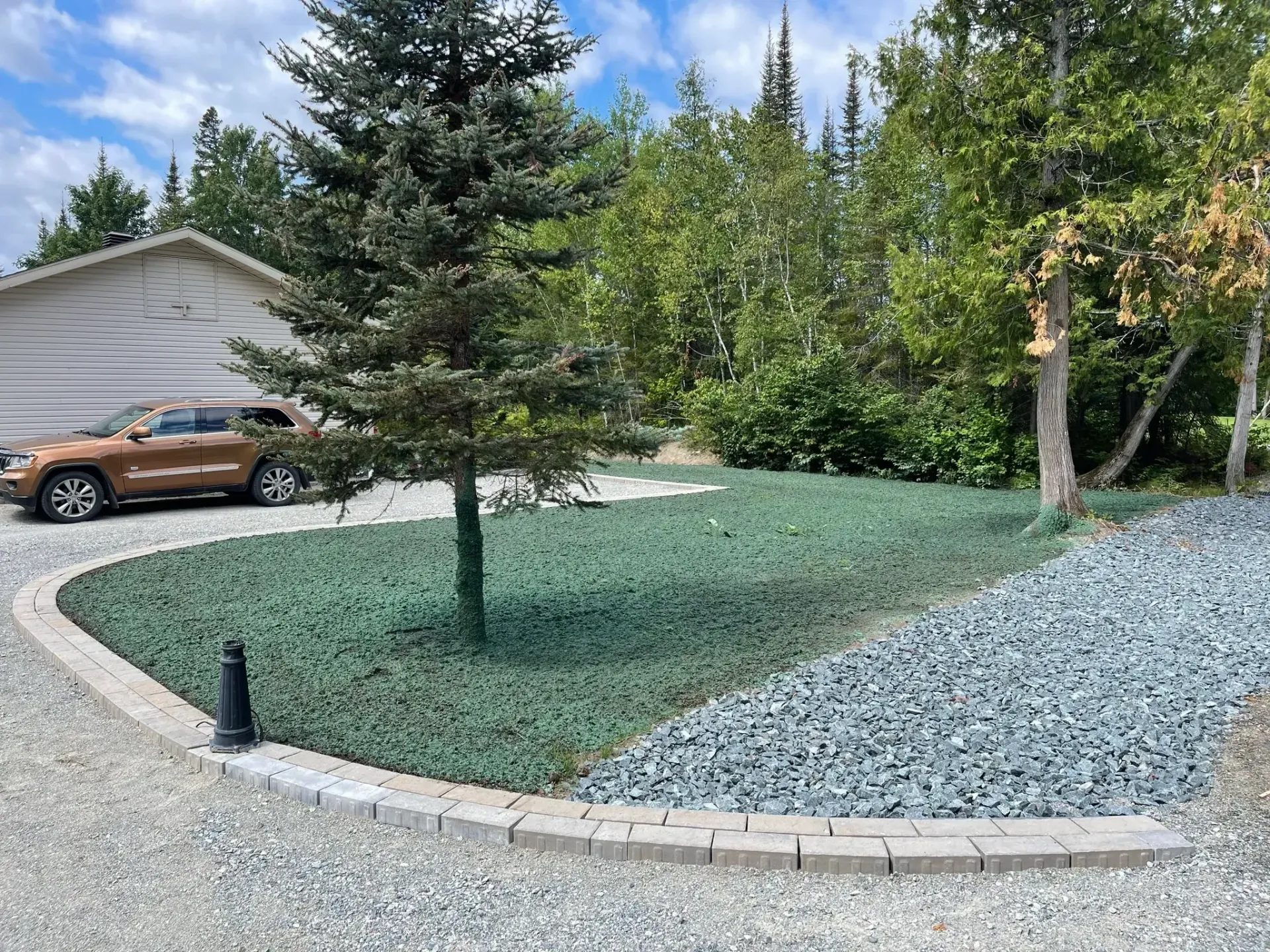 Une voiture est garée dans une allée devant une maison.