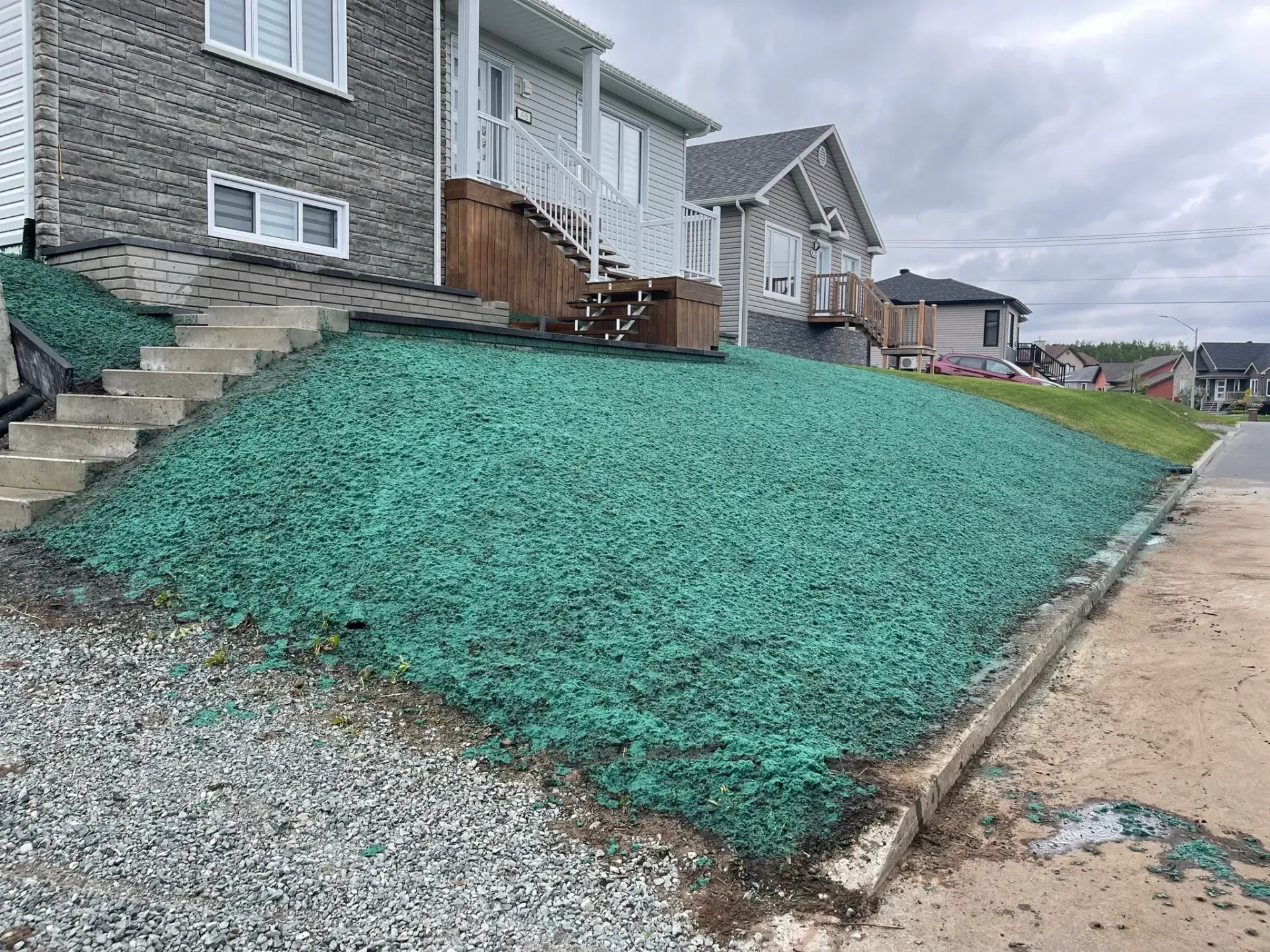 Une maison avec beaucoup de gravier vert sur les côtés.