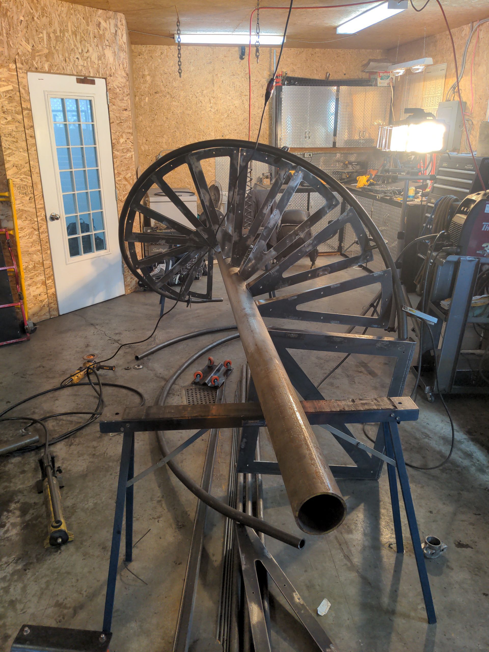 Escalier en colimaçon en construction à l'intérieur d'un atelier avec matériel et outils de soudage.