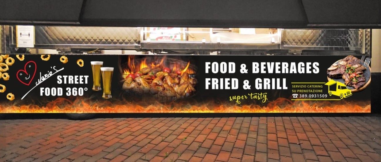 Un camioncino che vende cibo e bevande è parcheggiato su un marciapiede in mattoni.