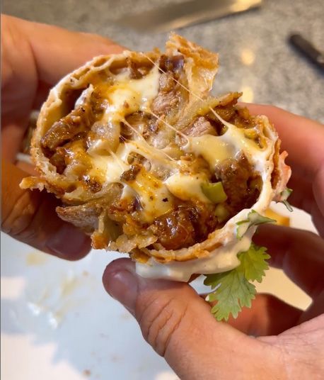 Un primo piano di una persona che tiene un burrito in mano