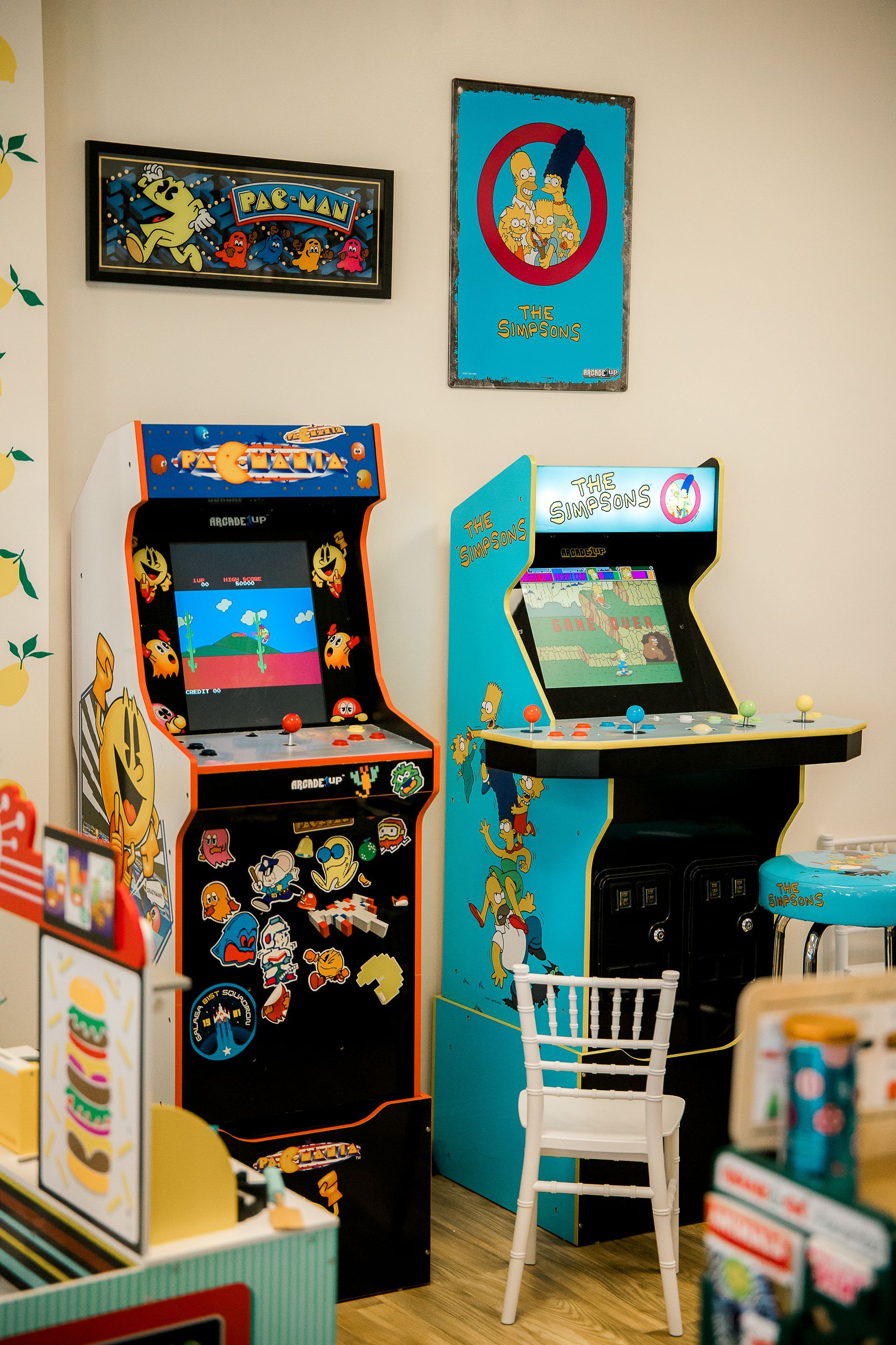 Two arcade games are sitting next to each other in a room.