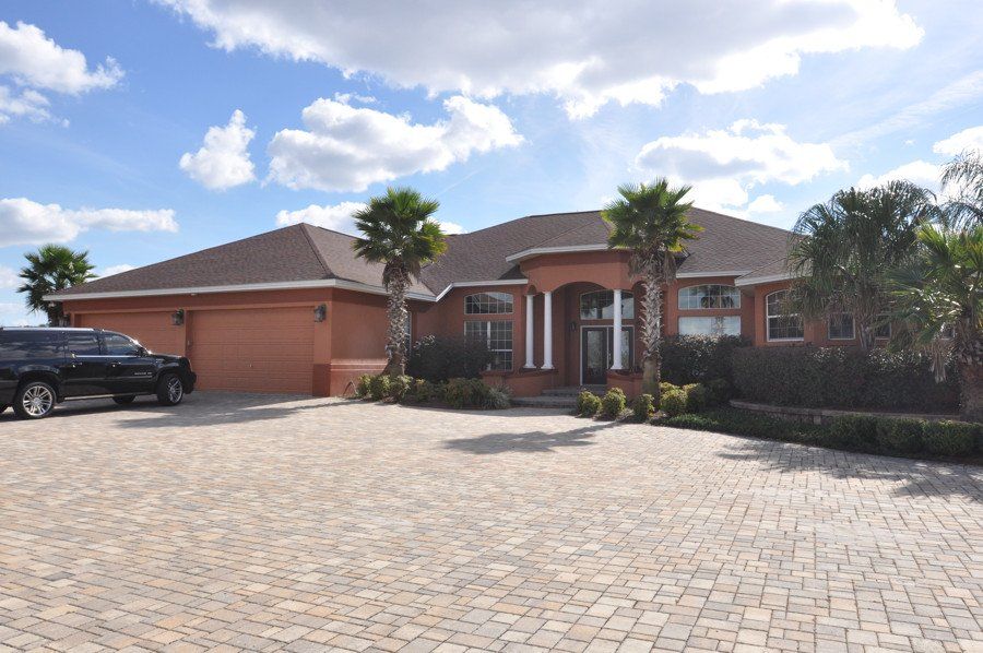 A black suv is parked in front of a large house