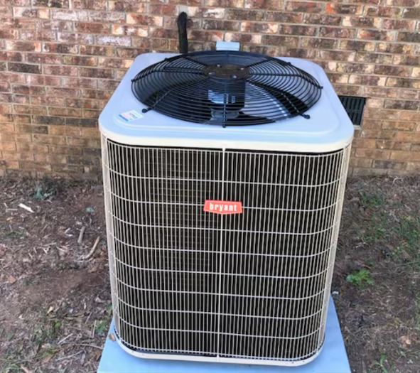 An air conditioner is sitting outside of a brick building.