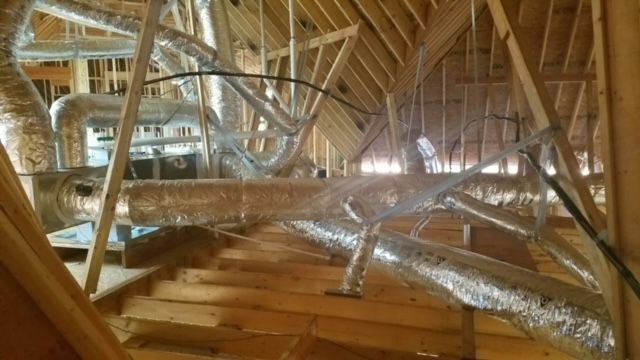 A bunch of pipes are hanging from the ceiling of a building.
