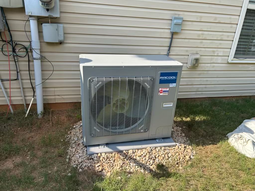 A large air conditioner is sitting outside of a house.