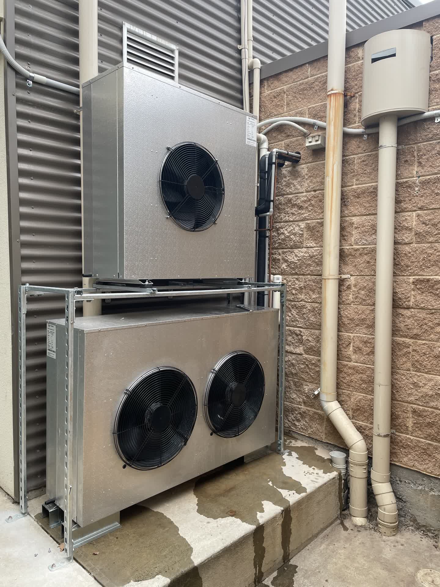 A large air conditioner is sitting on the side of a building.