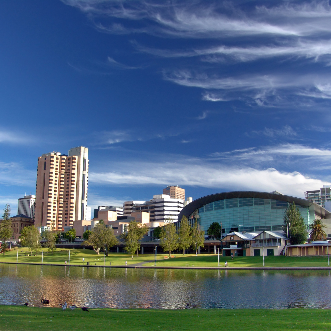 A city with a lake in the foreground and buildings in the background
