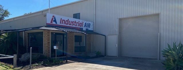 A large white building with a sign that says industrial air on it.