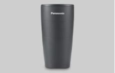 A black panasonic cup is sitting on a white surface.