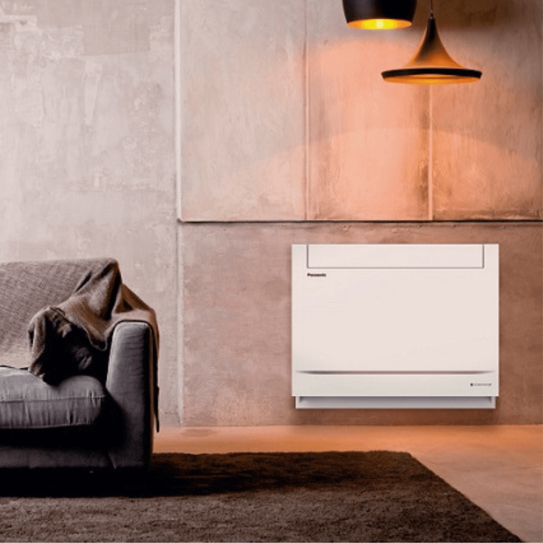 A living room with a couch and a wall mounted air conditioner.