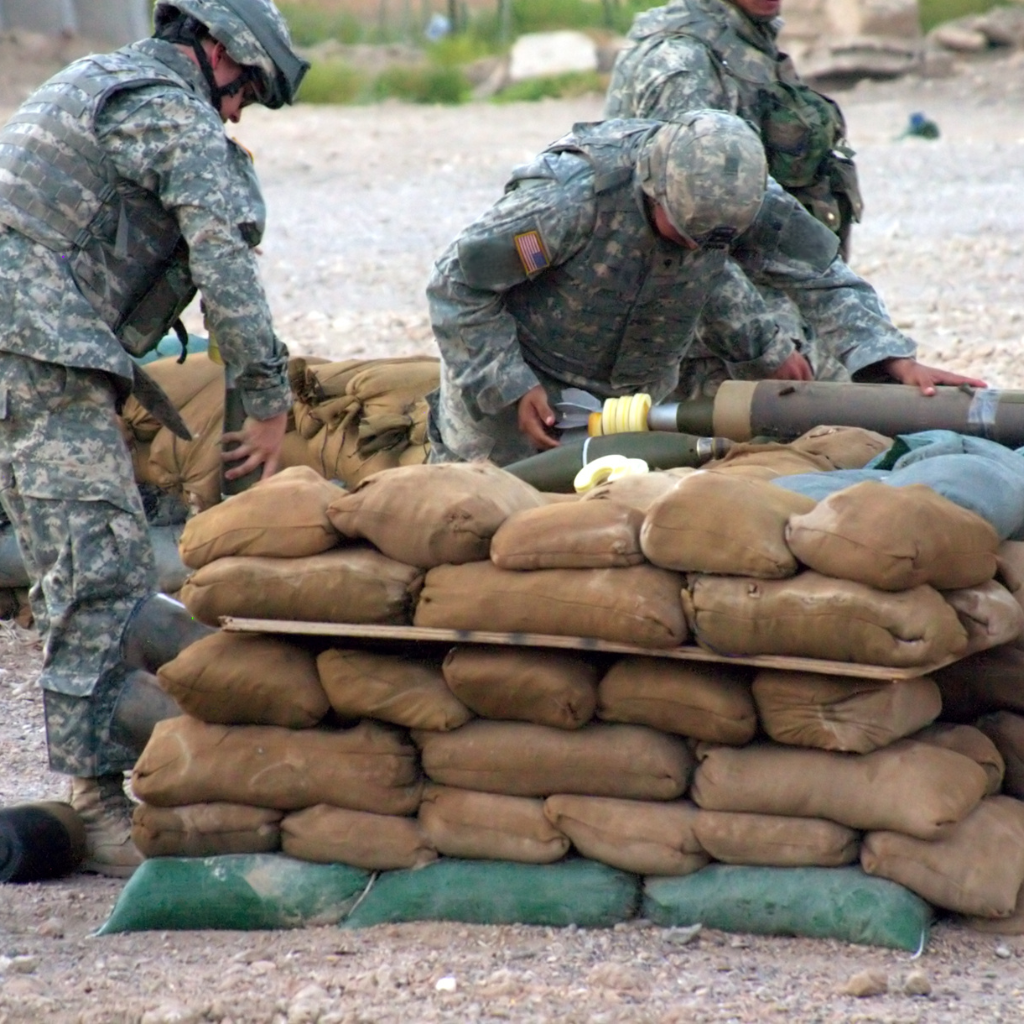 A group of soldiers are working on a pile of sandbags