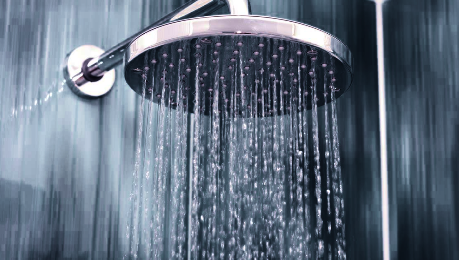 A close up of a shower head with water coming out of it.