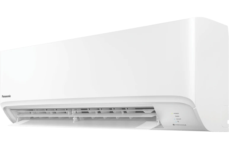 A white air conditioner is sitting on a white wall.
