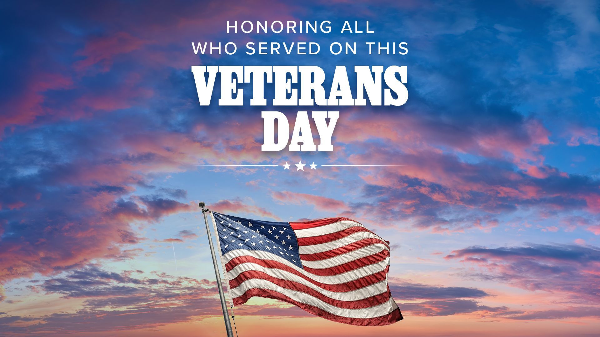 American flag waving against a colorful sunset sky, Veterans Day text overlay.