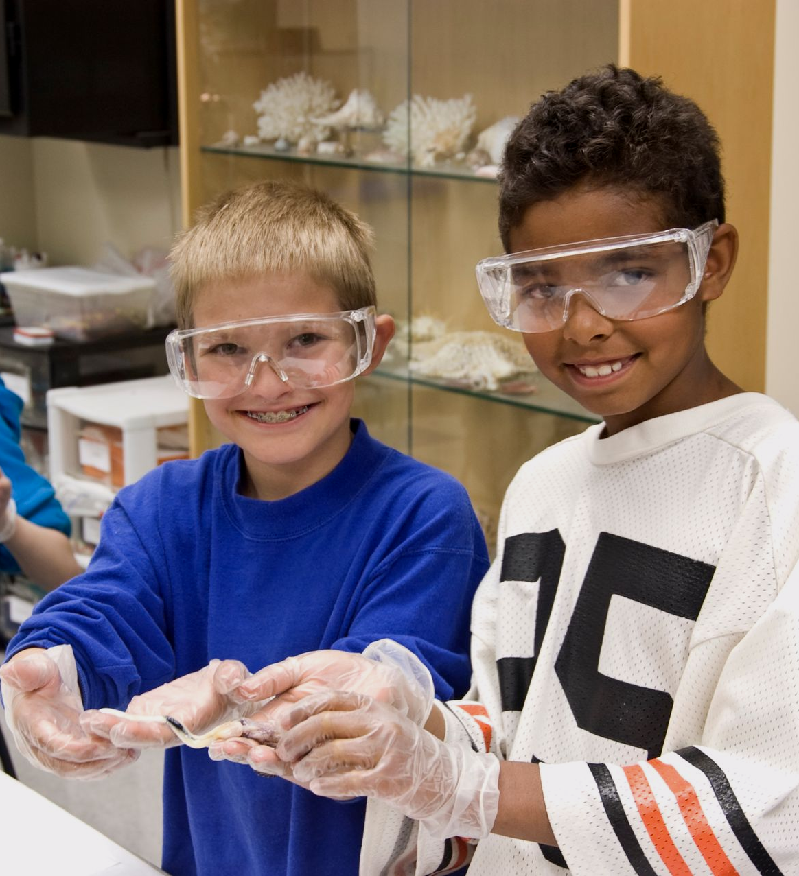 A young boy wearing a blue shirt that says marine biologist for a day