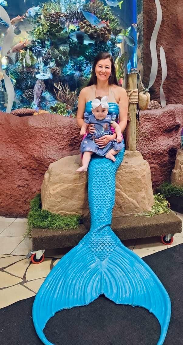 A man and a woman are looking at fish in an aquarium