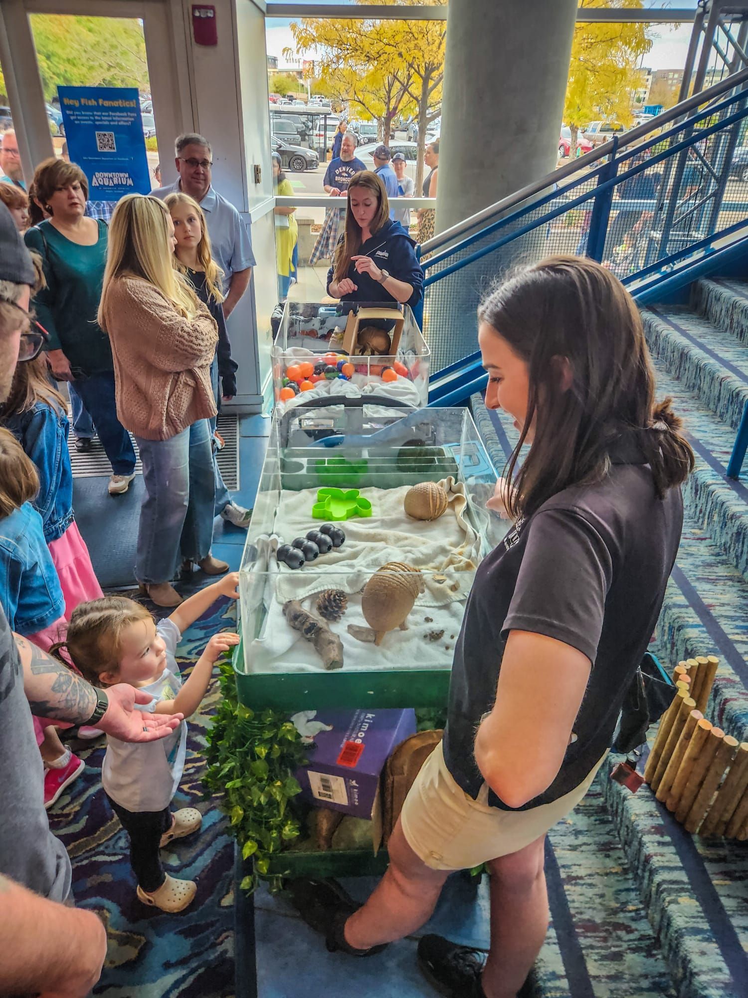 A woman stands in front of a table with a display of animals