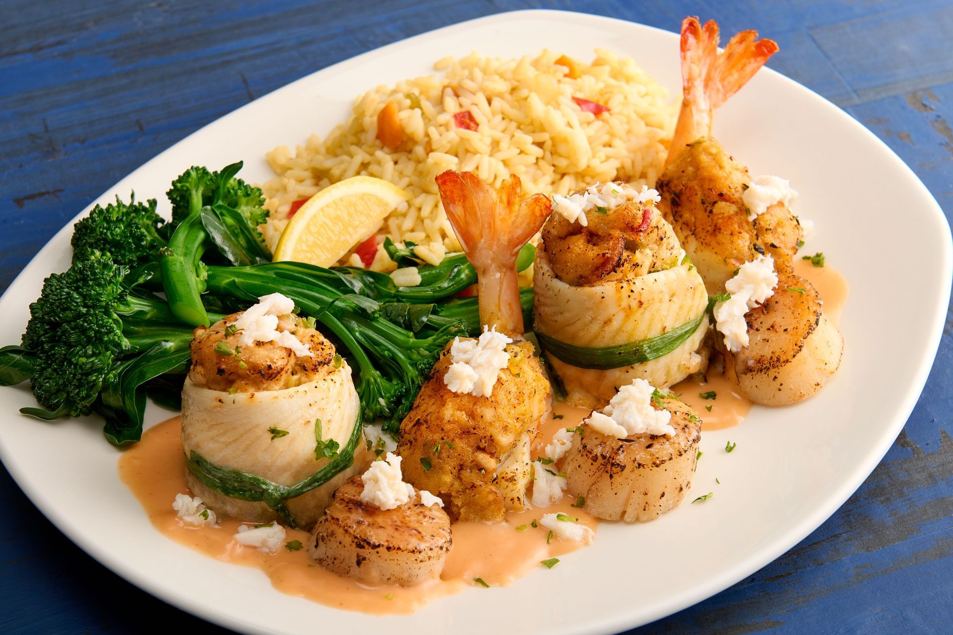 A white plate topped with seafood rice and broccoli