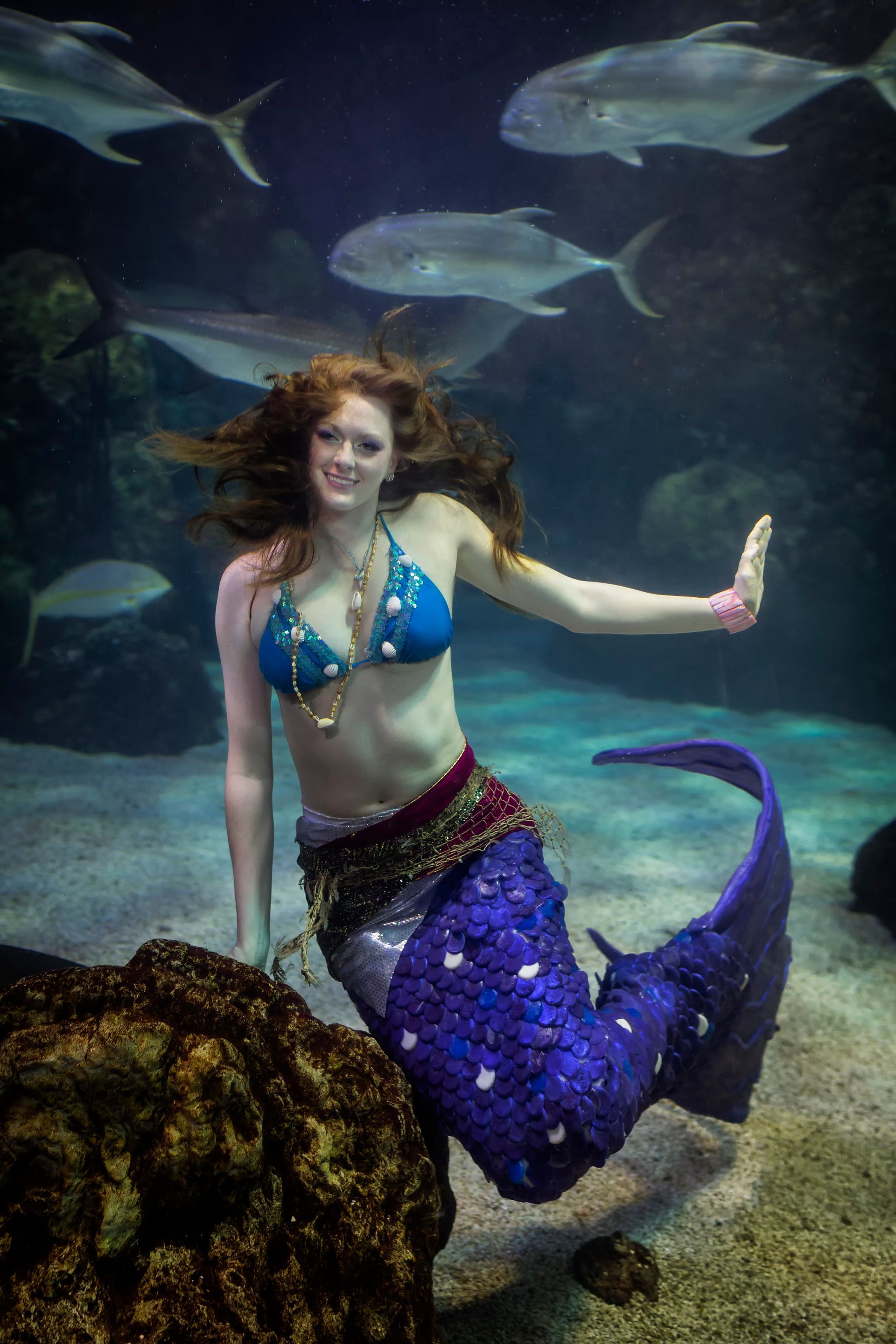 A woman dressed as a mermaid is swimming underwater