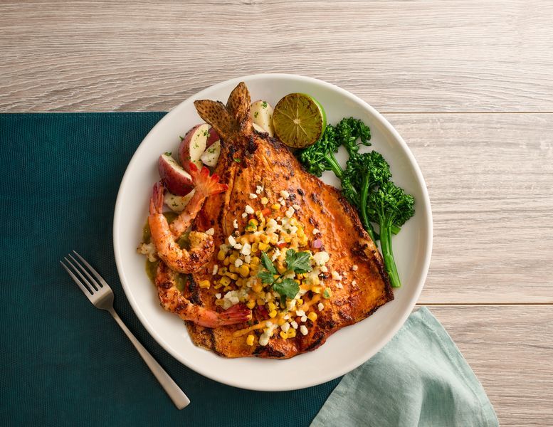 A white plate topped with seafood rice and broccoli