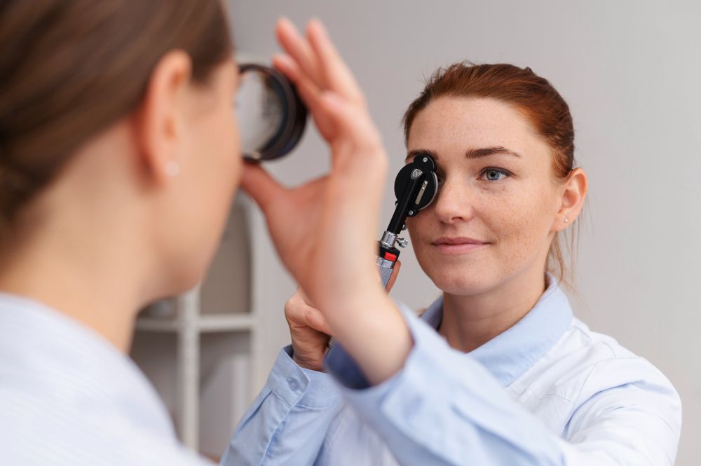 A female doctor is examining a patient 's eye with a magnifying glass.