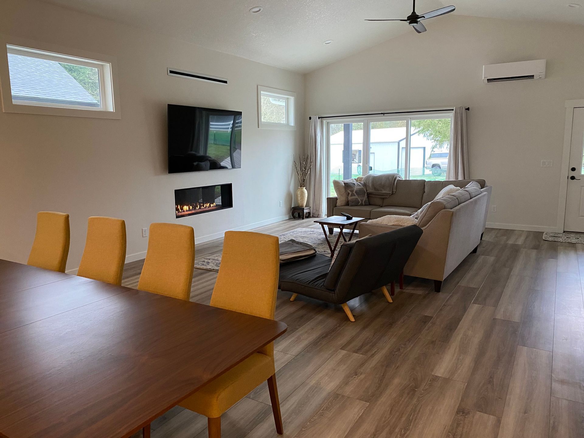 A living room with a dining table and chairs and a fireplace.
