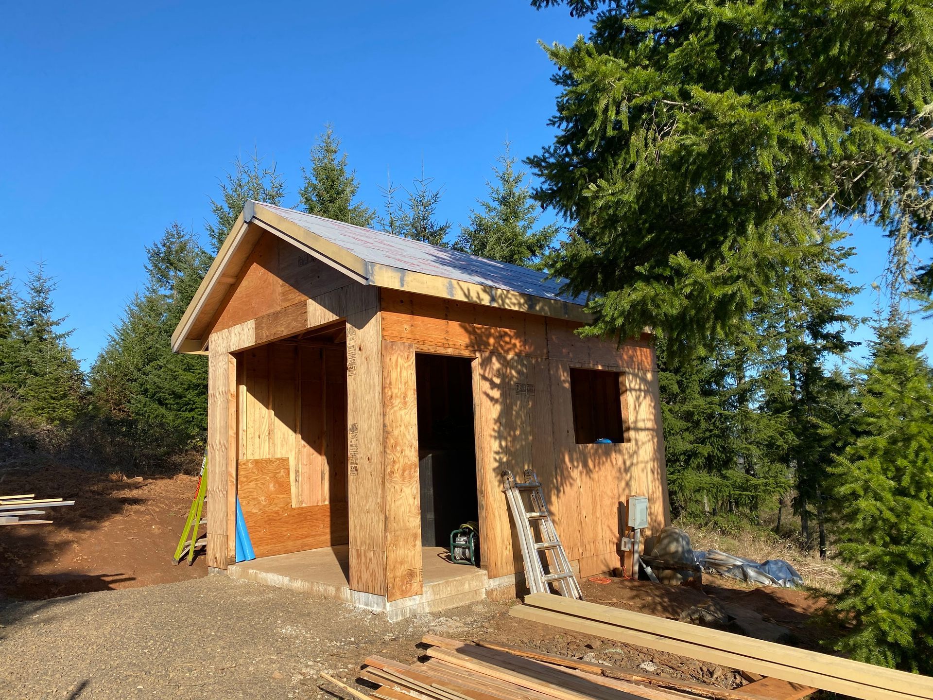 A small wooden shed is being built in the middle of a forest.