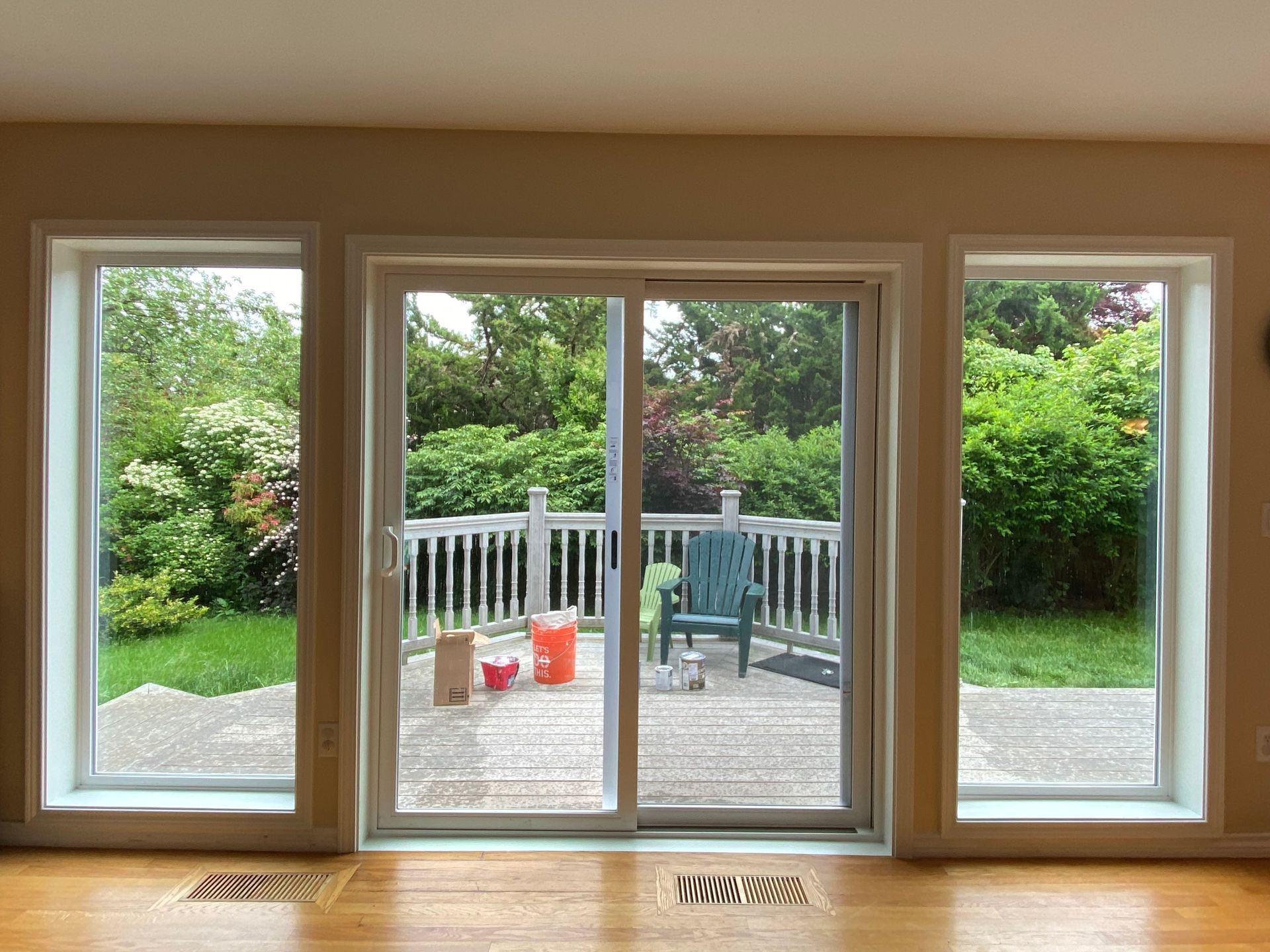 An empty room with a sliding glass door leading to a deck